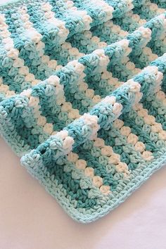 a blue and white crocheted blanket sitting on top of a table