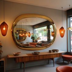 a large round mirror hanging above a wooden table