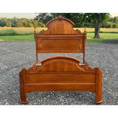 a wooden bed frame sitting on top of gravel