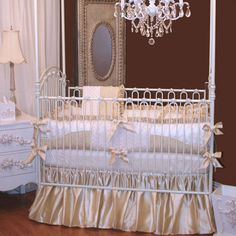 a white crib with a chandelier and mirror in the corner next to it