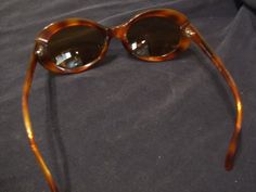 Vintage Giorgio Armani Made in Italy shades in tortoise shell with black accents. The lenses are a prescription for nearsighted. These have been used but are are in excellent condition. The hinges are still nice and tight. There are a few tiny scratches/scuffs on the lenses. These are very wearable and a classic. Please see the pics. These do not come with a case. If you need more photos let me know. Sent priority mail. For more more sunglasses, bags and accessories in my store click: https://ww Elegant Brown Oval Sunglasses, Designer Tortoiseshell Sunglasses For Formal Occasions, British Hong Kong, Toasting Glasses, Plastic Sunglasses, Vintage Bunny, Vintage Gothic, Button Flowers, Champagne Glasses