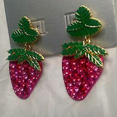 pair of strawberry earrings with green leaves on top and pink sequins in the bottom