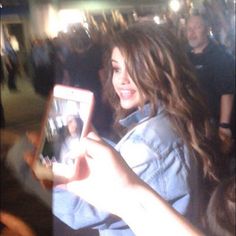 a woman is holding up her cell phone to take a selfie with the camera