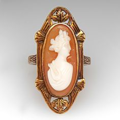 This lovely antique shell cameo cocktail ring has a nice low profile design and is crafted of 14k yellow gold. There are well preserved intricate details on the ring face and band and it has a gentle worn patina that further accentuates the designs. The ring is currently size 4.75 and polishing is not recommended, it is great as is. Vintage Carved Rings For Formal Occasions, Vintage Oval Carved Engraved Ring, Victorian Style Oval Engraved Ring, Vintage Filigree Ring With Intaglio For Formal Occasions, Vintage Filigree Intaglio Ring For Formal Occasions, Vintage Cameo Engraved Ring For Formal Occasions, Vintage Carved Rings For Formal Events, Victorian Oval Engraved Carved Ring, Antique Oval Filigree Ring