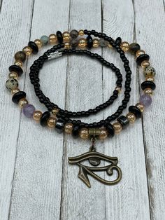 "🌟 Welcome to our shop! 🔥 ✨ Our handmade \"I am Protected\" Waist Beads with Eye of Horus Charm are the perfect blend of tradition and spirituality. ✨ 💎 Made with the highest quality materials and crafted with care, our waist beads are stretchy and come with a clasp for easy wearing and adjusting. They feature a beautiful Eye of Horus charm and multiple crystals including Amethyst, Hematite, Jasper, and Tiger Eye. Each of these crystals holds powerful energy that can enhance your spiritual jo Gold Amethyst Jewelry With 8mm Beads, Spiritual Amethyst Bead Jewelry, Spiritual Amethyst 8mm Beads Jewelry, Hand-strung Round Beads Amulet Jewelry, Spiritual Amethyst Jewelry With 8mm Beads, Beaded Amulet Jewelry For Meditation, Spiritual Polished Round Bead Jewelry, Spiritual Polished Round Beads Jewelry, Spiritual Style Polished Round Beads Jewelry