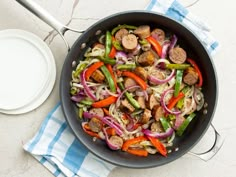 a skillet filled with sausage, peppers and onions