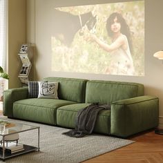 a living room filled with furniture and a large painting on the wall above it's couch