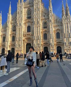 a woman standing in front of a large cathedral