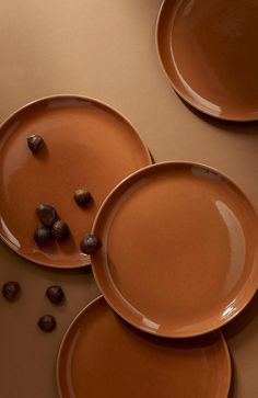 three brown plates sitting on top of a table next to chocolate chips and coffee beans