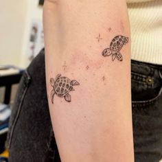 a woman's arm with two small turtles on the left side of her arm