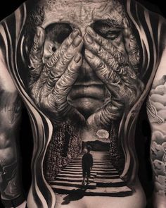 a man's back is covered in tattoos and features an image of a person holding their hands to his face