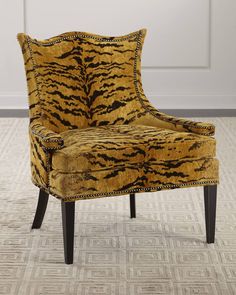 a tiger print chair sitting on top of a carpeted floor next to a white door