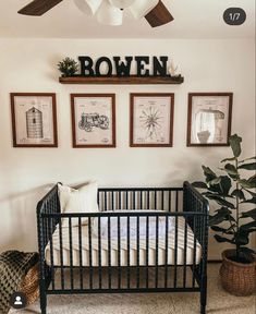 a baby crib in a room with pictures on the wall