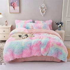 a bed with pink and blue fluffy blankets