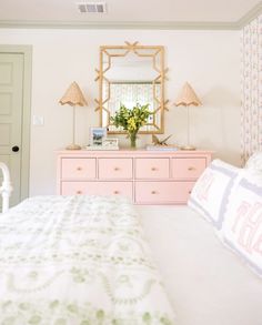 a bedroom with a bed, dresser and mirror in the corner that has flowers on it