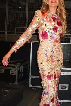 a woman in a floral dress posing for the camera