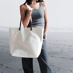 The perfect linen tote bag is an essential Summer accessory.  A great everyday bag that is timeless and modern.  Classic, textured linen is lightweight yet durable. and the neutral oatmeal color goes with just about anything.   Go ahead and stuff this bag with beach towels, books and laptops, it can handle it.  Roomy interior with easily accessible slip pockets and a large zipper pocket.   Will easily become your go-to bag all year long. Details: 14in H x 5in D x 17in W at top, 12in W at bottom Everyday Beach Bag With Leather Handles And Canvas Material, Everyday Canvas Beach Bag With Leather Handles, Everyday Canvas Tote Beach Bag, Everyday Summer Beach Bag With Rolled Handles, Everyday Cream Bag With Rolled Handles, Cream Bags With Rolled Handles For Everyday, Beige Everyday Beach Shoulder Bag, Everyday Beige Shoulder Beach Bag, Everyday Cream Bags With Rolled Handles