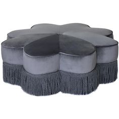 a round ottoman with tassels on it