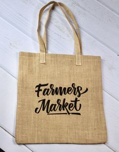 a jute bag with the words farmers market printed on it, sitting on a white wooden floor