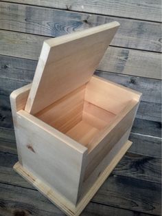 an empty wooden box sitting on top of a wooden floor