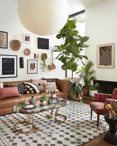 a living room filled with lots of furniture next to a large plant on the wall