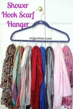 an assortment of scarves hanging on a coat rack