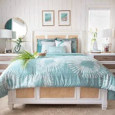 a bed with blue and white comforter in a bedroom next to two nightstands