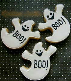 three decorated cookies sitting on top of a table