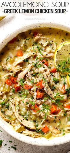 a white bowl filled with chicken soup and garnished with fresh herbs, lemon wedges and parsley