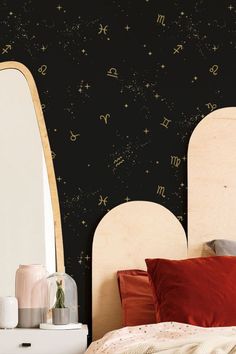 a bedroom with black wallpaper and gold stars