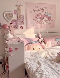 there is a bed with pink sheets and stuffed animals on the headboard in this room