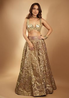 Introducing the Lampi lehenga set, a stunning ensemble that embodies timeless elegance and contemporary charm. The lehenga features intricate mirror work, meticulously handcrafted to accentuate its rich texture and vibrant hues. Paired with a matching mirror-embellished blouse and complemented by a mirror dupatta, this ensemble exudes grace and sophistication, perfect for any special occasion or celebration. Festive Gold Pre-draped Saree With Sequins, Gold Art Silk Palazzo Set With Traditional Drape, Gold Art Silk Palazzo Set For Diwali, Gold Pre-draped Saree For Navratri Party, Gold Pre-draped Saree For Reception And Festive Occasions, Diwali Gold Art Silk Palazzo Set, Glamorous Zari Work Sharara For Festive Season, Gold Art Silk Palazzo Set For Festivals, Glamorous Floor-length Sharara With Resham Embroidery