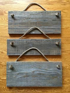 two wooden planks with rope hanging from them on a wood surface, one is made out of plywood and the other is painted blue