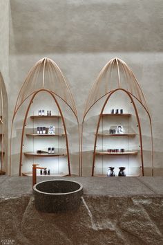 three wooden shelves with vases and other items on them in front of a wall