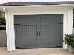 a gray garage door with two windows