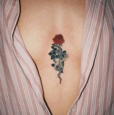 a woman's chest with a rose tattoo on her left side ribcage