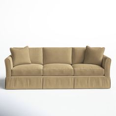 a beige couch with four pillows on it