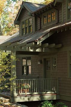 a house that has some plants on the front and side of it with trees in the background