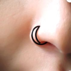 a close up of a person's nose with an arrow tattoo on it