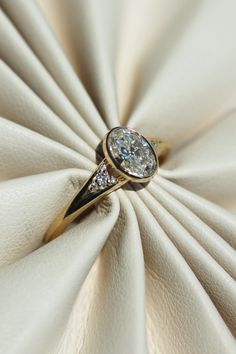 a diamond ring sitting on top of a white cloth