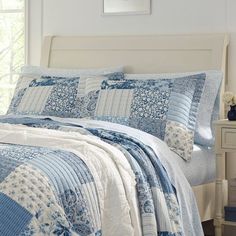 a blue and white quilted bed in a bedroom