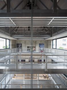 the inside of an industrial building with metal railings and stairs leading up to two floors