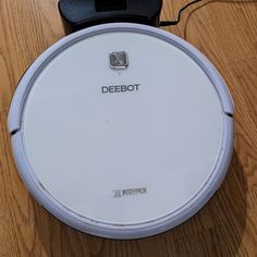 a white robot sitting on top of a wooden floor