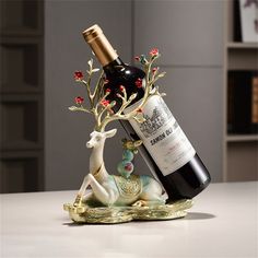 a bottle of wine sitting on top of a table next to a deer figurine