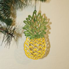 a pineapple ornament hanging from a christmas tree