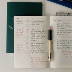 an open notebook with writing on it next to a pen