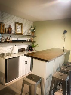 a kitchen with two stools and an island in front of the counter top is shown