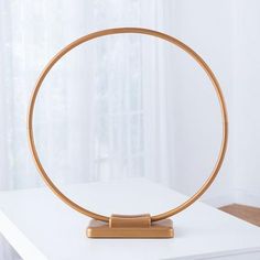 a round wooden object sitting on top of a white table in front of a window