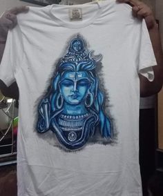 A beautiful hand painted unisex pure cotton t-shirt in white with Lord shiva painting on it ideal for festive wear and casual too. Pair it with denim or any cotton trousers and flaunt an attractive look. Painted with fabric colour and should be washed with hand with mild detergent. Iron it after every wash on the opposite side of the paint. White Cotton T-shirt With Custom Artwork, White Cotton Tops With Custom Artwork, Casual White T-shirt With Digital Print, Artistic Hand Painted Cotton Top, Traditional White Cotton T-shirt, Hand Painted White Short Sleeve Tops, Artistic White Cotton T-shirt, White Hand Painted Short Sleeve Tops, White Hand Painted Short Sleeve T-shirt