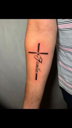 a person with a tattoo on their arm that has a cross and the word faith